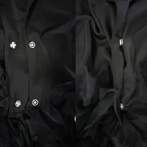 Close-up detail of silver metal snap buttons on elegant black tiered tulle cake dress