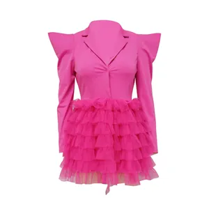 Detailed view of pink blazer dress with layered tulle ruffle skirt and pointed shoulders.