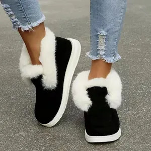 Detailoverzicht van zwarte suède winterlaarzen voor dames met witte rand van imitatiebont.