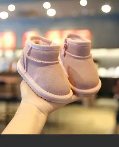 Gros plan de bottes de neige roses pour bébé en daim doux avec doublure en polaire