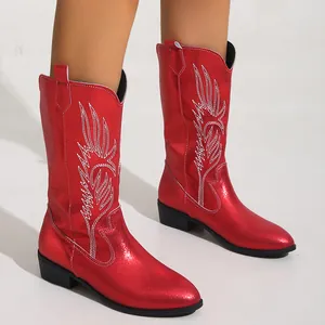 Détail de bottes western rouges métallisées avec broderie flamme blanche et petit talon.