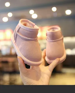 Gros plan de bottes de neige roses pour bébé avec doublure en peluche et daim