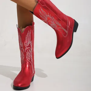 Vue détaillée des bottes de cow-boy rouges métallisées avec broderie aile et talon