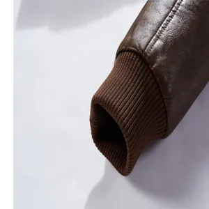 Gros plan de la manche d'une veste en similicuir marron avec détail de poignet en tricot.
