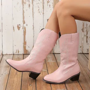 Vue de côté des bottes de cow-boy roses brodées avec talons épais noirs.