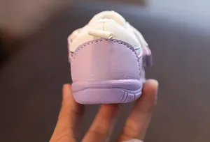 Makroansicht der Ferse und Sohle eines lila-weißen, warmen Winter-Sneakers für Kleinkinder