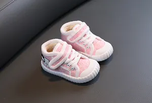 Detail van roze gevoerde kinderwinterschoenen met klittenband en schattige berenpatch