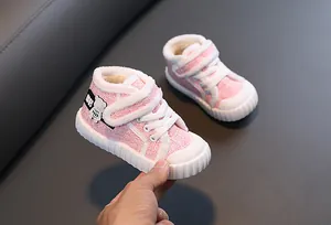 Close-up van roze wintergympen voor kinderen met warme witte pluche voering en antislipzolen