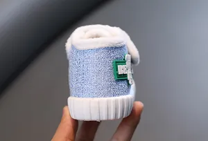 Detail van blauwe katoenen kinderschoen met warme witte fleecevoering en dikke antislipzool.
