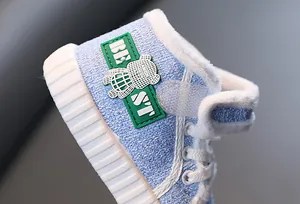 Close-up van blauwe kinderwinterschoen met zachte fleecevoering en berenpatch detail.