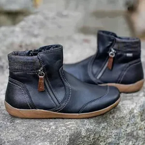 Close-up detail of women's black leather ankle boots with plaid collar and side zipper