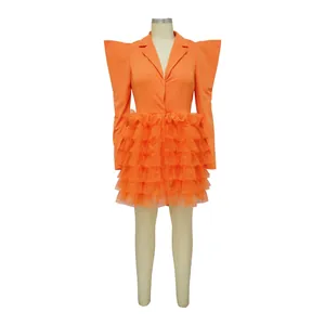 Close-up detail of the layered orange tulle ruffles on this vibrant mini cake dress.