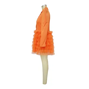 Side view of orange blazer dress with layered ruffle mesh skirt on mannequin