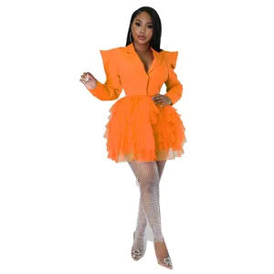 Close-up detail of a bright orange tiered tulle blazer dress with dramatic puffy shoulders
