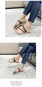 Close-up detail of stylish black flat thong sandals for women featuring sparkling rhinestones