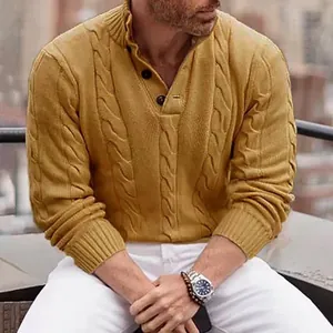 Primo piano della trama a trecce e del colletto a bottoni del maglione color senape