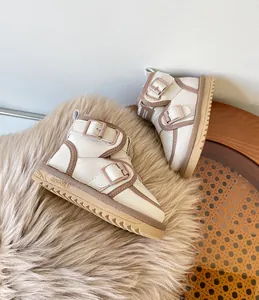 Close-up of beige toddler winter snow boots with brown buckle straps on fur