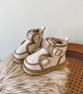 Detailed macro view of cream toddler snow boots showing plush lining and buckle design