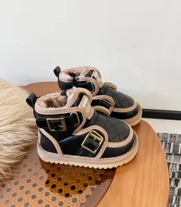 Close-up detail of baby winter snow boots featuring warm faux fur lining and buckle straps