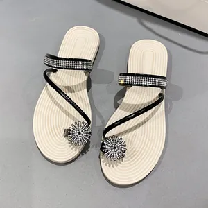Elegant women's flat sandals featuring rhinestone straps and sparkling flower toe loop