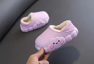 Primo piano di pantofole invernali viola per bambini con fodera calda e motivo a nuvola.