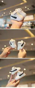 Close-up of white fleece-lined baby walking shoes with soft soles for winter warmth.