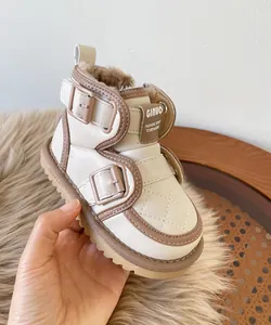 Macro view of beige baby snow boots highlighting warm plush lining and buckle details