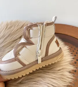 Close-up detail of beige baby winter snow boots with warm fleece lining and side zipper