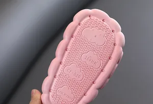 Primo piano della suola rosa antiscivolo con motivo a nuvola di una pantofola per bambini