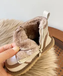 Close-up showing the thick brown faux fur lining of white baby winter snow boots for warmth