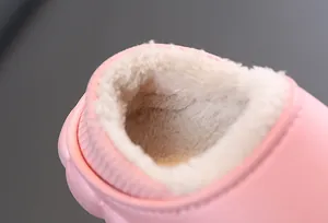 Dettaglio dell'imbottitura in pile beige all'interno delle pantofole rosa per bambini