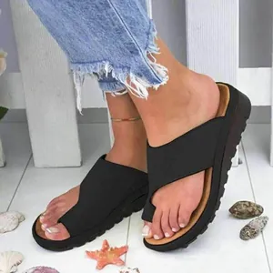 Detailansicht der schwarzen Keilsandaletten für Damen mit Zehenschlaufe und Jeans