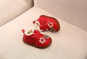 Detailansicht der roten Baby-Winterstiefel mit weichem Kunstfellfutter und Blumendekor.