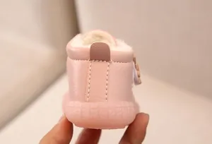 Detail eines rosa Baby-Schneestiefels mit weichem Fellfutter und Gummisohle.