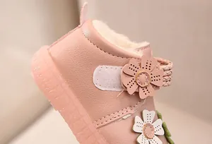 Nahaufnahme der rosa Baby-Winterstiefel mit warmem Fellfutter und Blumenakzenten