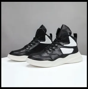 Vue latérale détaillée de baskets montantes en cuir noir et blanc au design perforé