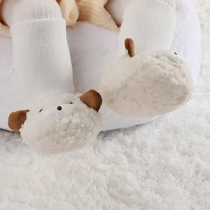 Primer plano detallado de patucos de peluche con forma de oso y orejas marrones.