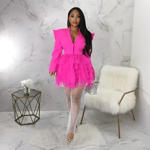 Full view of hot pink blazer dress with ruffled skirt in a modern marbled room setting