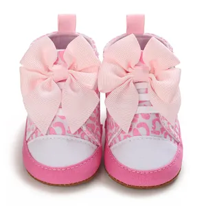 Vorderansicht rosa Leoparden-Babyschuhe mit großen Schleifen für Mädchen, weiche Sohle.