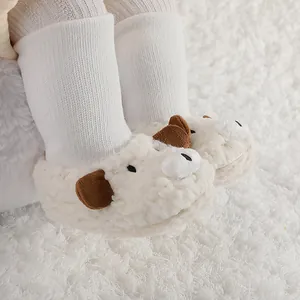 Primer plano de patucos de peluche para bebé con forma de oveja blanca y orejas marrones.