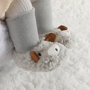 Primer plano de botas de bebé de felpa gris con detalles de orejas en alfombra blanca.
