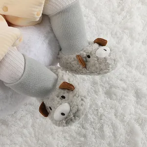 Primer plano de adorables botas de peluche para bebé con forma de oveja en alfombra