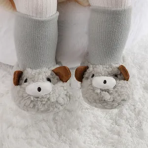 Detalle de primeros planos de botines de felpa para bebé con diseño de oso gris de dibujos