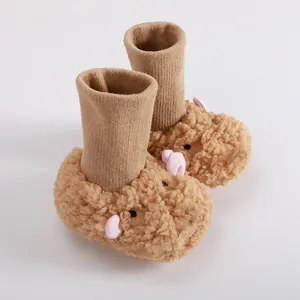 Detail of plush baby walking shoes with cute lamb design and soft knitted cuff.