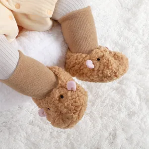 Gros plan de chaussures bébé chaudes en peluche avec motif capybara sur tapis