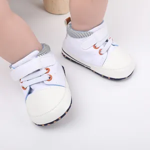 Nahaufnahme von weißen Lauflernschuhen für Babys mit Lederkappe und Klettverschluss