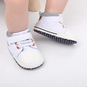 Nahaufnahme von weißen Baby-Lernlaufschuhen mit gestreiftem Knöchel und rutschfester Sohle.
