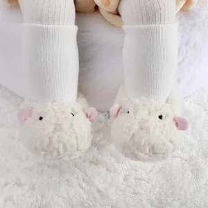 Vue détaillée de adorables bottes de bébé en peluche blanche en forme d'agneau