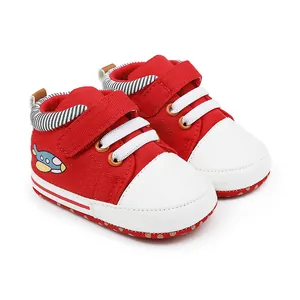 Nahaufnahme von roten Baby-Lauflernschuhen aus Stoff mit gesticktem Cartoon-Flugzeug