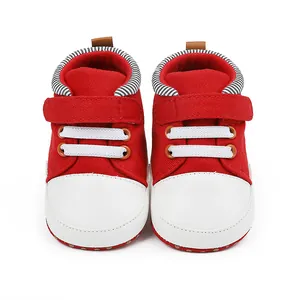 Nahaufnahme von rot-weißen Baby-Lauflernschuhen aus Segeltuch mit Klettverschluss, 0-1 Jahr